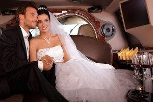 bride and groom in back of a limo